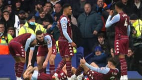 Les défenseurs d'Aston Villa, le Français Lucas Digne (2e d) et Matty Cash (d), s'écroulent, touchés par une bouteille, à la fin de la 1ère mi-temps du match de Premier League contre Everton, le 22 janvier 2022.