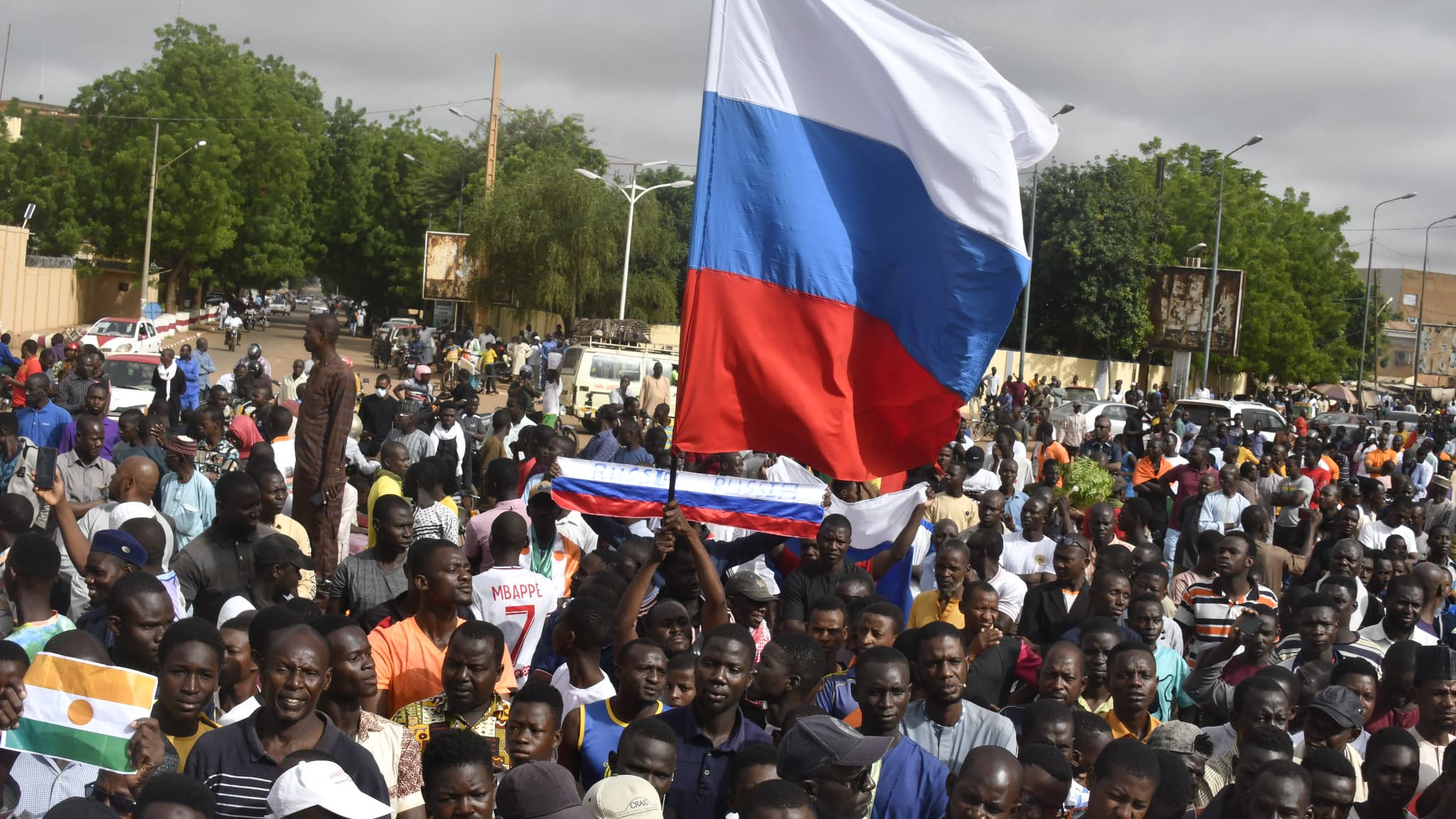 Des manifestants brandissent un drapeau russe lors d'une manifestation organisée à l'occasion de la fête de l'indépendance à Niamey, le 3 août 2023. Des manifestants brandissent un drapeau russe lors d'une manifestation organisée à l'occasion de la fête de l'indépendance à Niamey, le 3 août 2023.