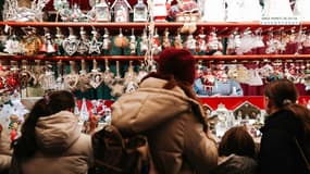 Des visiteurs regardent les décorations de Noël en vente au marché de Strasbourg, le 27 novembre 2024 dans le Bas-Rhin