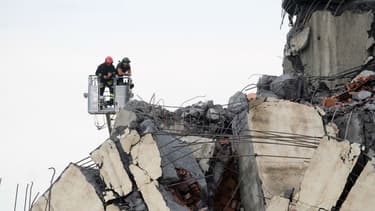 Les secouristes reconnaissent les décombres du viaduc Morandi.