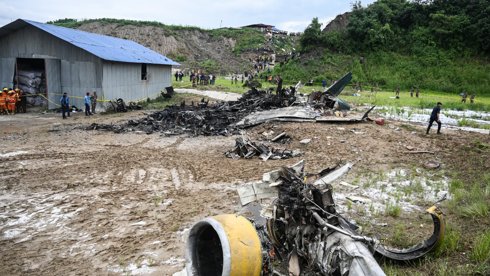 Des sauveteurs sur le site du crash d'un avion de Saurya Airlines au décollage à l'aéroport international de Tribhuvan à Katmandou, le 24 juillet 2024.