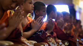 Les enfants thaïlandais rescapés d'une grotte inondée assistent à une cérémonie marquant la fin de leur retraite dans un monastère bouddhiste, le 4 août 2018 au temple Wat Phra That Doi Tung de Mae Sai, dans la province de Chiang Rai