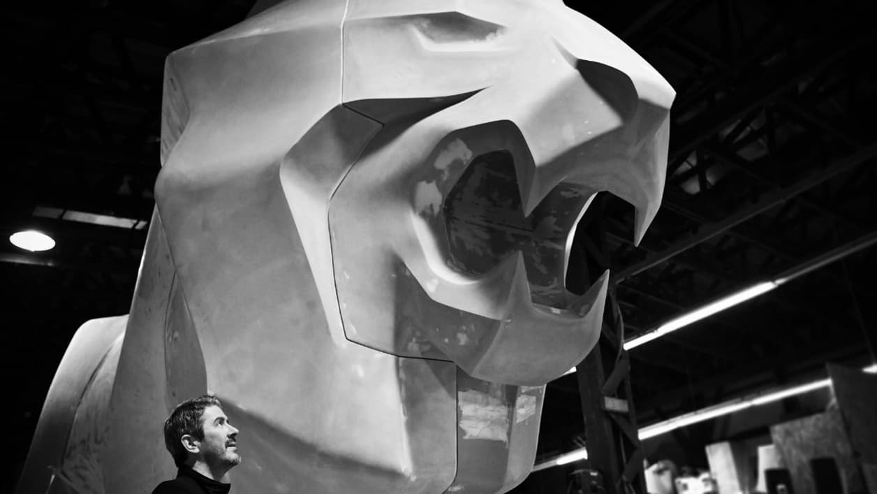 Gilles Vidal, le designer en chef de Peugeot, à côté de la statue du Lion.