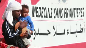 Un homme porte un enfant en descendant d'un navire de Médecins Sans Frontières à Salerne en Italie en 2017 (image d'illustration)