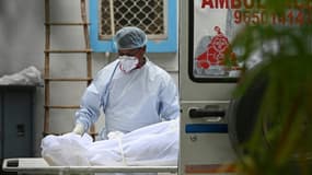 Le corps d'une personne décédée du Covid-19 est chargé dans une ambulance pour le transporter à la morgue, le 18 mai 2021 à New Delhi, en Inde