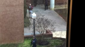 Policier sur le campus de l'université américaine Virginia Tech où deux personnes, dont un policier, ont été tuées jeudi dans des échanges de tirs. /Photo prise le 8 décembre 2011/REUTERS/Katherine Davison