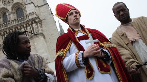 Trois comédiens grimés en homme d'Eglise et en esclaves devant la cathédrale Notre-Dame-de-Paris, lundi 11 mars.