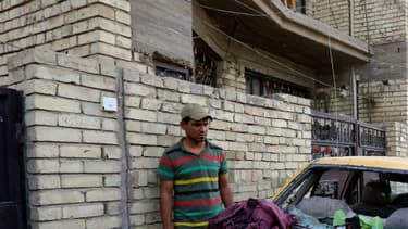 Une voiture endommagée sur le site de l'attentat suicide revendiqué par l'EI et qui visait les musulmans chiites le 15 octobre 2016, dans un quartier de Bagdad.