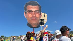 Des fans brandissent un portrait de Xavier Dupont de Ligonnes sur le bord de la route du Tour de France le 18 juillet 2025