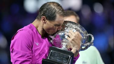 L'Espagnol Rafaël Nadal embrasse son trophée après battu le Russe Daniil Medvedev en finale de l'Open d'Australie, le 31 janvier 2022 à Melbourne