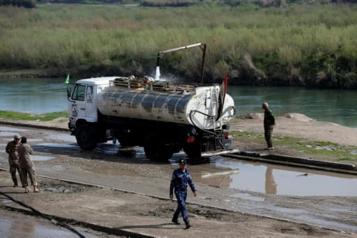 Des soldats irakiens surveillent le remplissage en eau d'un camion-citerne, le 1er avril 2017 à Hamman al-Alil Des soldats irakiens surveillent le remplissage en eau d'un camion-citerne, le 1er avril 2017 à Hamman al-Alil