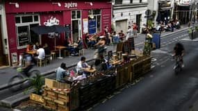 Des personnes prennent un verre à la terrasse élargie d'un bar à Paris, le 23 juillet 2020