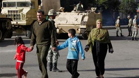 Une famille passe à proximité de soldats dans le centre du Caire. L'armée égyptienne a promos de ne pas ouvrir le feu sur les manifestants hostiles au président Hosni Moubarak. Le vice-président, issu des rangs de l'armée, a pour sa part annoncer l'ouvert