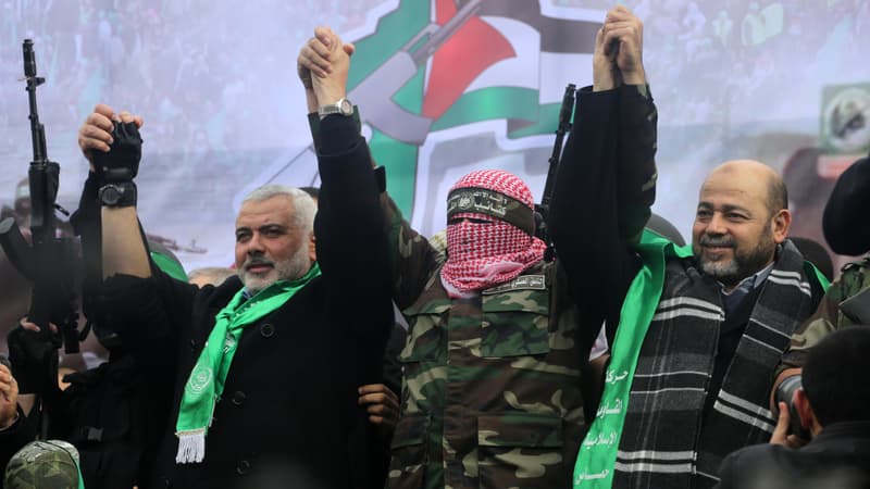 Des leaders du mouvement Hamas: Ismail Haniya (G), porte-parole des Brigades Ezzedine Al-Qassam, Abu Obaida et Moussa Abou Marzouq (D) saluent  les partisans pendant un défilé marquant le 27e anniversaire de la création du mouvement islamiste le 14 Décembre, 2014 dans la ville de Gaza. 