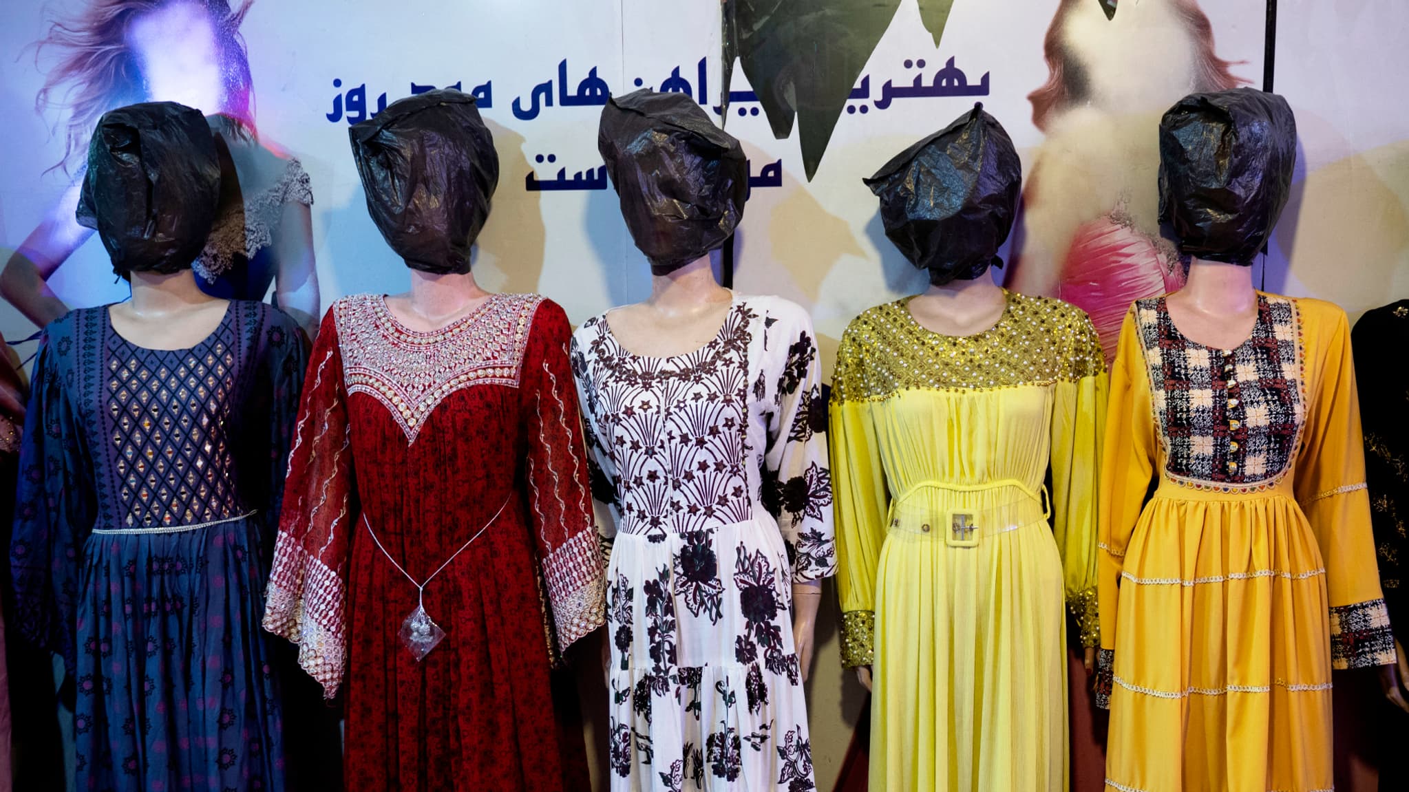 Voilated models dressed in female outfits are photographed in a store in Kabul, on July 25, 2024. Under the arrangements 