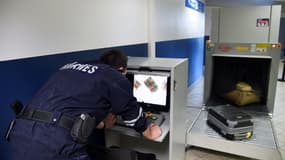 Un douanier contrôle des bagages le 17 mars 2015 à l'aéroport Roissy-Charles de Gaulle