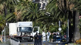 Des policiers et des experts légistes devant le camion qui a foncé sur le foule rassemblée le soir du 14 juillet sur la promenade des Anglais, au lendemain de l'attentat, le 15 juillet 2016 à Nice.