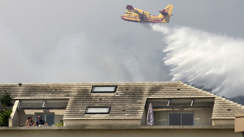 Un Canadair passe au-dessus des maisons à Ortale de Biguglia après un incendie en Corse, le 25 juillet 2017.