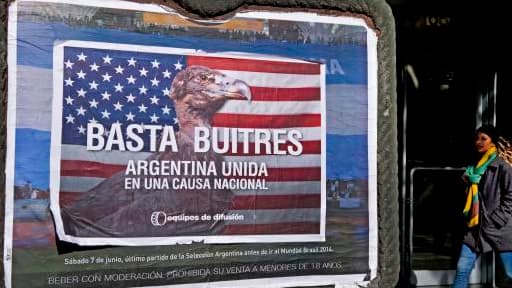 A Buenos Aires, une passante marche à côté d'un poster qui dénoncer les "fonds vautours".