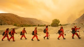 Photo de détenus-pompiers, dans leur tenue orange, arrivant sur les lieux d'un incendie en Californie, aux Etats-Unis, le 2 août