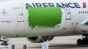 Des militants de Greenpeace ont repeint partiellement un avion Air France à l'aéroport Roissy-Charles de Gaulle, au nord de Paris, le 5 mars 2021, accusant le gouvernement de "greenwashing" sur les enjeux environnementaux autour du trafic aérien