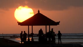 Des personnes regardent le lever du soleil depuis la plage de Sanur, près de Denpasar, sur l'île indonésienne de Bali, le 4 août 2019 (photo d'illustration).