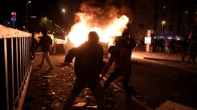 Des manifestants lancent des projectiles contre les forces de police après l'arrestation du rappeur Pablo Hasel, le 17 février 2021 à Barcelone