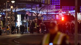 Des gens se tiennent à l'endroit où un camion a foncé sur la foule, à Berlin, lundi 19 décembre 2016.