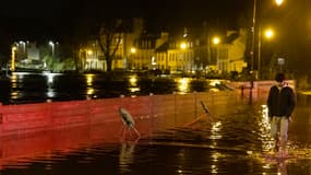 Un homme marche dans une rue inondée à Quimperlé, dans l'ouest de la France, le 21 janvier 2026.