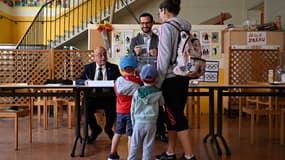 Une femme en train de voter avec ses deux garçons aux élections européennes du 9 juin 2024 à Vanves.