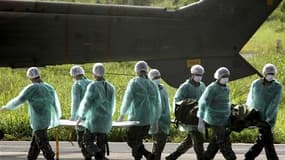 Des soldats brésiliens transporte le corps d'une victime du vol AF447 Rio-Paris. Les enquêteurs ont annoncé lundi avoir identifié 153 victimes de l'accident de cet appareil, qui a fait 228 morts le 1er juin 2009. /Photo d'archives/REUTERS/JC Imagem/Renato