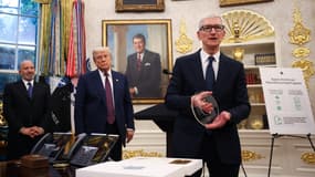 Le PDG d'Apple, Tim Cook, remet au président américain Donald Trump un disque en verre gravé lors d'un événement organisé dans le bureau ovale de la Maison Blanche, le 6 août 2025, à Washington, DC. 