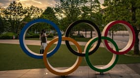 Des gens prennent des photos avec les anneaux olympiques, à côté du musée des Jeux Olympiques à Tokyo, le 17 mai 2021 