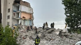 Des pompiers dans les décombres d'un immeuble de Tchassiv Iar, dans le Donetsk, après une frappe russe faisant au moins 6 morts, le 10 juillet 2022