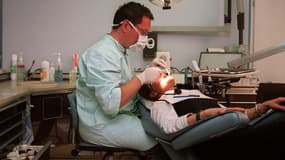 Un chirurgien-dentiste traite une patiente, le 19 juin 2001, à Paris.