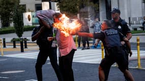 La police aide un homme qui a tenté de s'immoler par le feu alors pendant une manifestation contre la guerre à Gaza près de la Maison Blanche à Washington, DC, le 5 octobre 2024.
