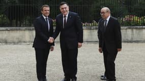 Le président Emmanuel Macron et le chef du gouvernement de Tripoli Fayyez al-Sarraj se serrent la main, accompagnés du ministre français des Affaires étrangères Jean-Yves Le Drian, à La Celle-Saint-Cloud, près de Paris, le 25 juillet 2017