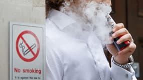 Un individu qui vapote à côté d'un logo d'interdiction de fumer
