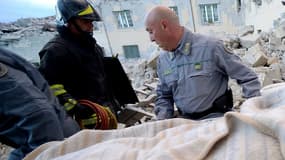 Les secours évacuent un blessé à Amatrice le 24 août, après le fort séisme qui a frappé le centre de l'Italie dans la nuit. 